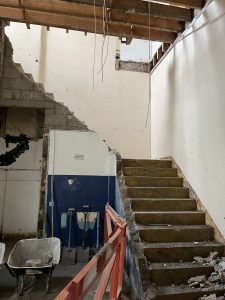 Demolition of the accessible toilet and wall, along with the caretaker's store and office. The staircase leads up to the Town Hall and is also being removed. 